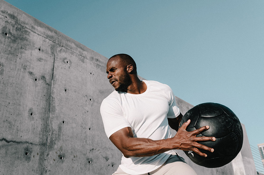 Man athlete throwing fitness ball